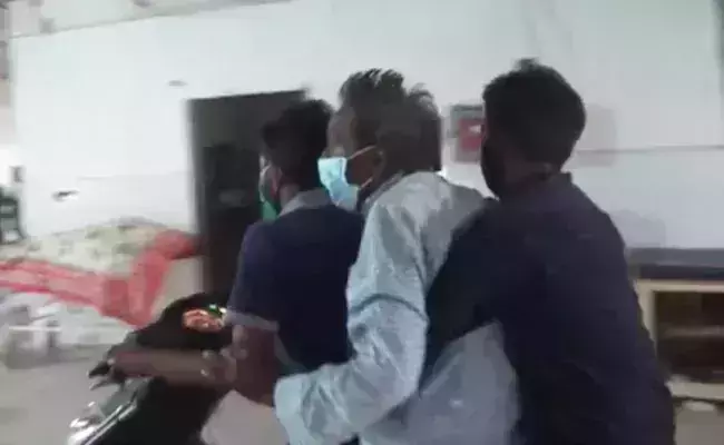 സ്ട്രക്ചറില്ല, കോവിഡ് രോഗിയേയും കൊണ്ട് ആശുപത്രി വാർഡിലൂടെ സ്‌കൂട്ടറോടിച്ച് യുവാക്കൾ