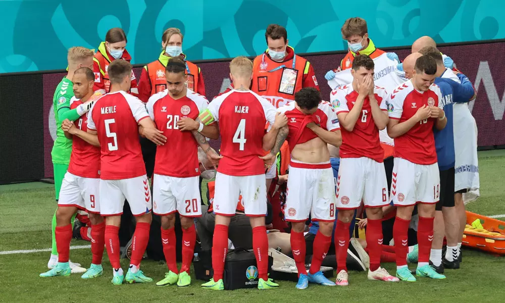 എറിക്‌സണ് പുതയ്ക്കാൻ ഫിൻലാൻഡ് പതാക, കരുതലിന്റെ മനുഷ്യമതിലൊരുക്കി സഹതാരങ്ങൾ; കൈയടിച്ച് ലോകം