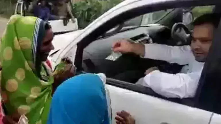 കാറിനു മുന്നില്‍ തടിച്ചു കൂടിയ സ്ത്രീകള്‍ക്ക് നോട്ടുകള്‍ വാരി വിതറി തേജസ്വി യാദവ്; വിവാദമായി വീഡിയോ