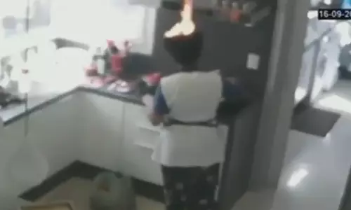 അടുക്കള ജോലിക്കിടെ സ്ത്രീയുടെ മുടിയില്‍ തീപിടിച്ചു, കത്തുന്നത് അറിയാതെ ജോലി തുടര്‍ന്നു: വൈറലായി വീഡിയോ