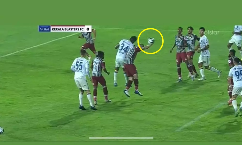 എടികെ ബോക്സില് വച്ച് ജോണി കൌകോയുടെ കൈയില് തട്ടുന്ന പന്ത് എടികെ ബോക്സില് വച്ച് ജോണി കൌകോയുടെ കൈയില് തട്ടുന്ന പന്ത്