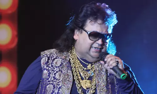 കയ്യിലും കഴുത്തിലും നിറയെ സ്വര്‍ണം; പൊന്നില്‍ കുളിച്ച് പാടാനെത്തുന്ന ബപ്പി ലാഹിരി