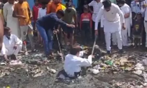 അഴുക്കുചാലിലിറങ്ങി മാലിന്യം നീക്കി എഎപി കൗണ്‍സിലര്‍, തുടര്‍ന്ന് പാലില്‍ കുളിയും