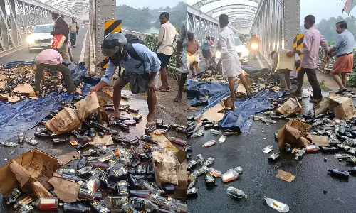 കോഴിക്കോട്ട് മദ്യം കയറ്റിവന്ന ലോറി പാലത്തിൽ തട്ടി കുപ്പികൾ തെറിച്ചുവീണു; വാരിക്കൂട്ടി നാട്ടുകാര്‍