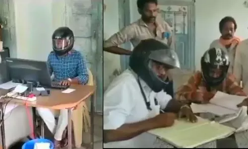Telangana,Govt Employees Wear Helmet While Working Inside The Office,Dangerous working condition,ഹെല്‍മറ്റിട്ട് ജോലി,സര്‍ക്കാര്‍ ഓഫീസില്‍ ഹെല്‍മറ്റിട്ട് ജോലി,തെലങ്കാന