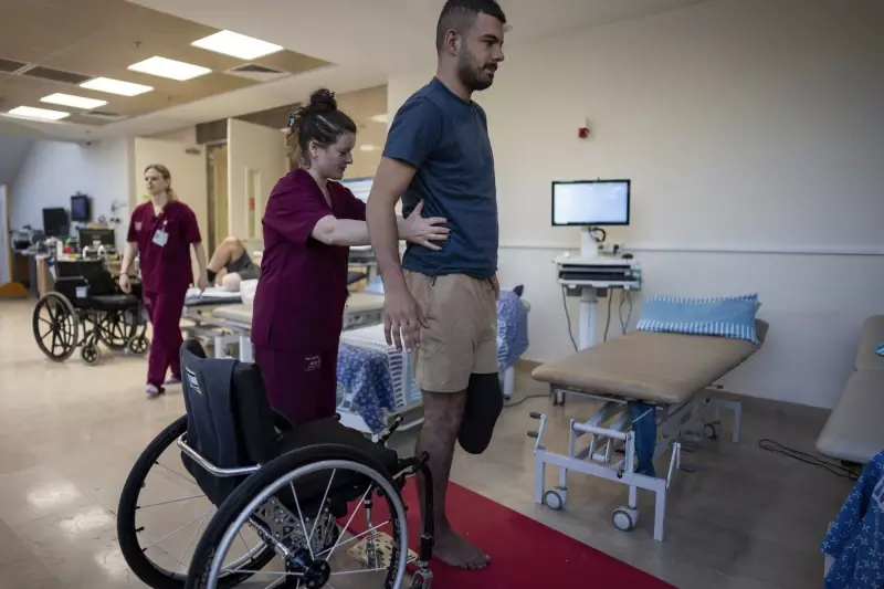 യുദ്ധത്തിൽ കാൽ നഷ്ടമായ ഇസ്രായേൽ സൈനികൻ ഷേബ ആശുപത്രിയിൽ ഫിസിയോ തെറാപ്പിസ്റ്റിന്റെ സഹായത്തോടെ എണീറ്റുനിൽക്കാൻ ശ്രമിക്കുന്നു യുദ്ധത്തിൽ കാൽ നഷ്ടമായ ഇസ്രായേൽ സൈനികൻ ഷേബ ആശുപത്രിയിൽ ഫിസിയോ തെറാപ്പിസ്റ്റിന്റെ സഹായത്തോടെ എണീറ്റുനിൽക്കാൻ ശ്രമിക്കുന്നു