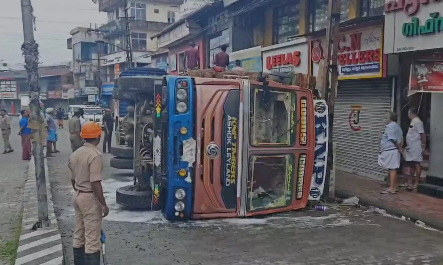 Lorry loaded with timber overturns in front of Kothamangalam Municipal Bus Stand Lorry loaded with timber overturns in front of Kothamangalam Municipal Bus Stand
