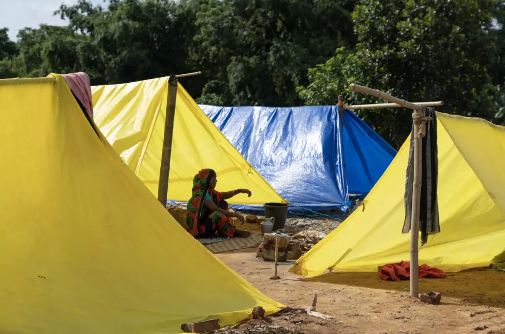 ചൗബക്രയിൽ ടാർപോളിൻ ടെൻ്റുകളിൽ ഒരു സ്ത്രീ പാചകം ചെയ്യുന്നു. ഫോട്ടോ: കാസി ഷരോവർ ഹുസൈൻ, ദി വയർ