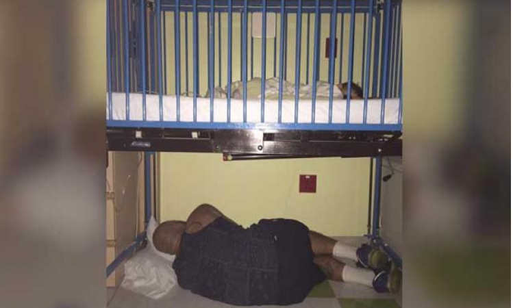 രോഗിയായ മകളുടെ തൊട്ടിലിനടിയില്‍ ഉറങ്ങുന്ന പിതാവിന്റെ ചിത്രം വൈറലാകുന്നു