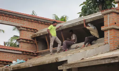 പൊള്ളുന്ന വെയില്‍ വകവെക്കാതെ കൂറ്റന്‍ കെട്ടിടങ്ങളുടെ മുകളില്‍ തൊഴിലാളികള്‍